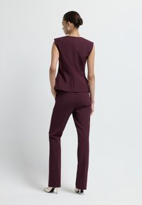 Top senza maniche color marrone scuro su misura e pantaloni abbinati. Tessuto morbido con linee delle spalle nette, caratterizzati da una vestibilità dritta e minimi dettagli.