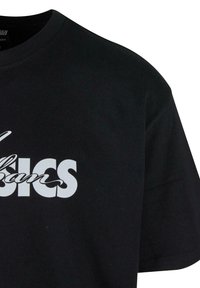 Juodas medvilnės marškinėliai trumpomis rankovėmis, su dideliu baltu grafiniu tekstu, kuris skelbia "Urban Basics" per krūtinę.