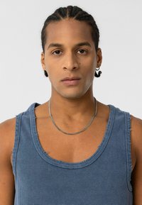 Blauw geribbelde tanktop met rafelige randen en een ronde halslijn, gecombineerd met een zilveren ketting. Soepele textuur, nauwsluitend ontwerp.