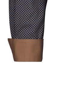 Pantaloni fantasia realizzati in un tessuto blu navy con forme geometriche bianche. Il fondo presenta un contrasto di marrone chiaro, cucito con cura.