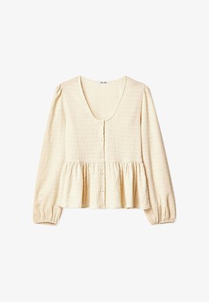 Kreminės spalvos palaidinė su apvaliu iškirpimu, ilgomis pūstomis rankovėmis, mygtukų užsegimu ir priekyje sluoksniuotu peplumu. Audinys su tekstūra ir subtiliomis raukšlėmis.