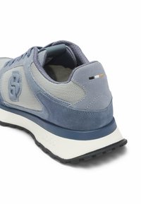 Scarpa sportiva blu realizzata in un mix di materiali suede e mesh, con tallone rinforzato, accenti bianchi e neri a contrasto e suola testurizzata.