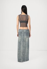 Pilkas tinklinis trumpas viršus su plonomis petnešėlėmis, derinamas su ilgu šviesiai mėlynu gyvačių odos rašto džinsiniu sijonu, turinčiu nugarines kišenes ir tiesų kirpimą.