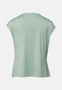 Chemise vert clair à manches courtes avec une coupe ample, montrant le dos avec un col rond et des coutures minimales.