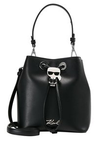 Sort læder bucket-taske med sølvdetaljer, snørelukning og en legesyg karakterdetalje. Har en aftagelig skulderrem.