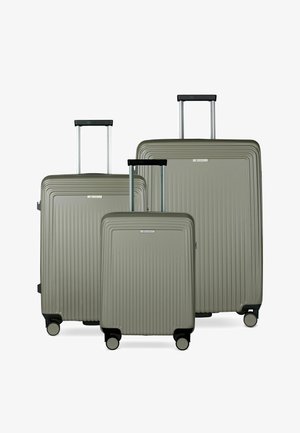 Trois valises rigides de tailles différentes avec des rainures verticales, des poignées télescopiques étendues et quatre roulettes chacune, de couleur grise atténuée.