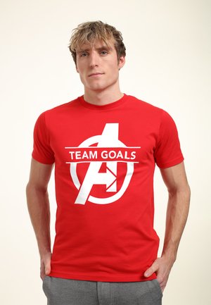 Rød bomulds t-shirt med hvid grafiktekst "TEAM GOALS" og logo i midten. Kortærmet og med rund hals.