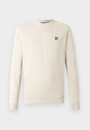 Sweatshirt bege claro com mangas compridas, punhos e gola canelados. Apresenta pequeno logótipo de pássaro preto e amarelo no lado esquerdo do peito. Textura suave.