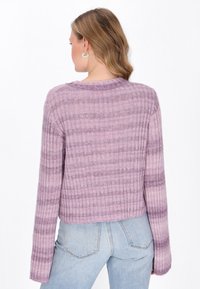 Jasnofioletowy krótki sweter o prążkowanej fakturze, z poziomymi paskami i długimi rękawami. Nosi się go na dżinsy.