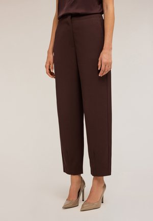 Pantalon taille marron à coupe droite, avec des poches avant et une texture lisse, associé à des chaussures à talons hauts beiges.
