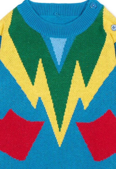 Maglione lavorato a maglia con colletto blu e bottone, con motivi a zigzag verdi, gialli e stelle rosse su sfondo blu.