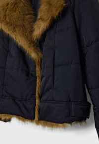 Zwarte pufferjas met een bruine bontkraag, voorzien van doorgestikte stiksels en een taille met ceintuur. De textuur is glad met een zachte bontaccent.