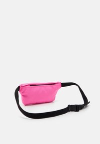 Różowa saszetka na pas z zamkiem błyskawicznym, czarnym regulowanym paskiem i teksturowaną powierzchnią dla lepszego chwytu. Kompaktowy i lekki design.