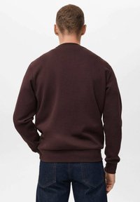 Bordo svetrovni pulover iz mehkega materiala, z okroglo ovratnikom in rebrastimi manžetami. Zadnji pogled prikazuje gladko teksturo in sproščen kroj.