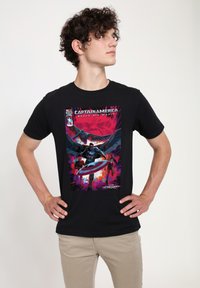 Playera de algodón negra con diseño gráfico de Capitán América, estilo cómic colorido con figuras y texto en negrita, forma ajustada y mangas cortas.