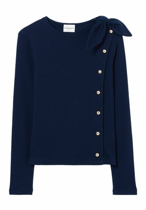 Haut à manches longues marine avec un détail en nœud à l'épaule gauche, des boutons décoratifs sur le côté et une texture de tissu lisse.