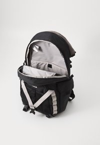 Black backpack with gray interior, zippered main compartment, mesh side pockets, and adjustable straps. Features a reinforced base.