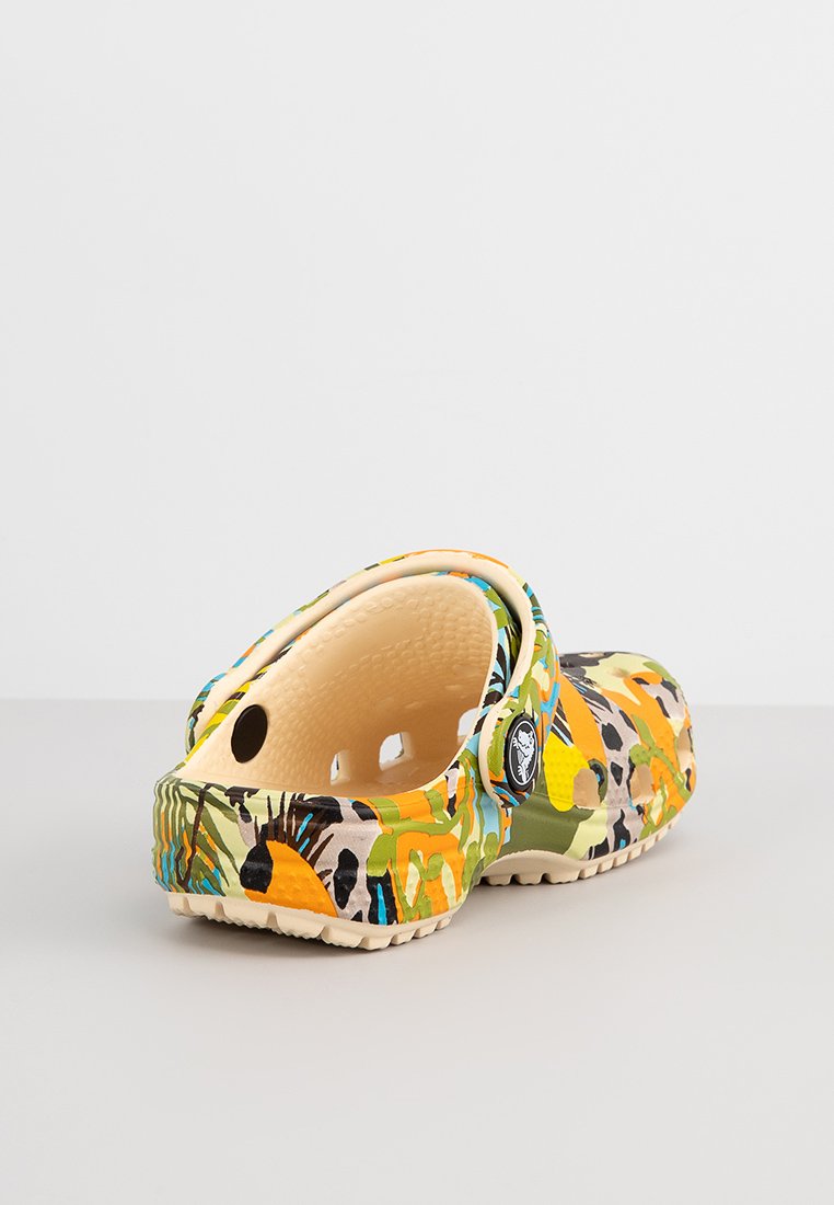 Zuecos multicolores en amarillo, verde y naranja con patrones abstractos; hechos de un material ligero con agujeros de ventilación y una plantilla texturizada.