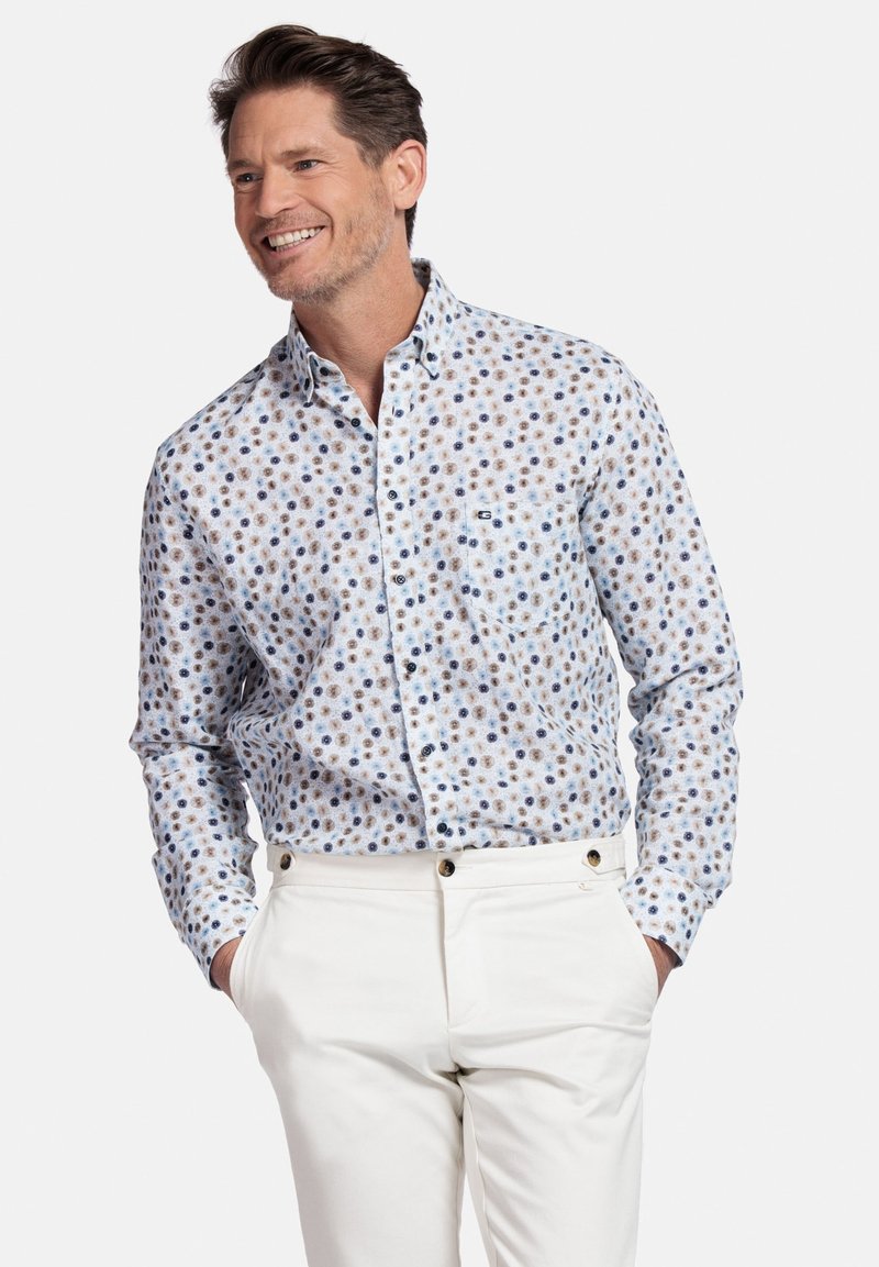 Lange mouwen overhemd met een lichtblauwe kleur en een klein, veelkleurig bloemenpatroon. Bevat een enkele borstzak en knoopmanchet.
