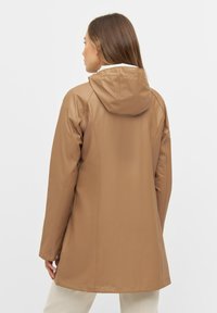 Chaqueta impermeable marrón claro con capucha, textura suave, mangas largas y un ajuste ligeramente acampanado, con detalles de costura sutiles.