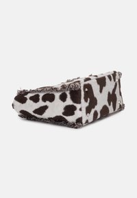 Borsa a stampa mucca in tessuto morbido, tonalità di grigio e marrone, bordi frangiati, dettagli in hardware argentato e una forma distintiva a triangolo.