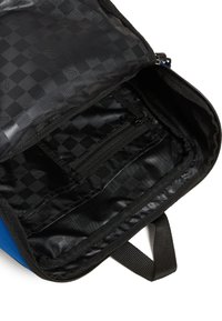 Zaino blu con interno nero caratterizzato da un motivo a scacchi, tasca con cerniera e rivestimento in tessuto nero. Realizzato con materiali resistenti.