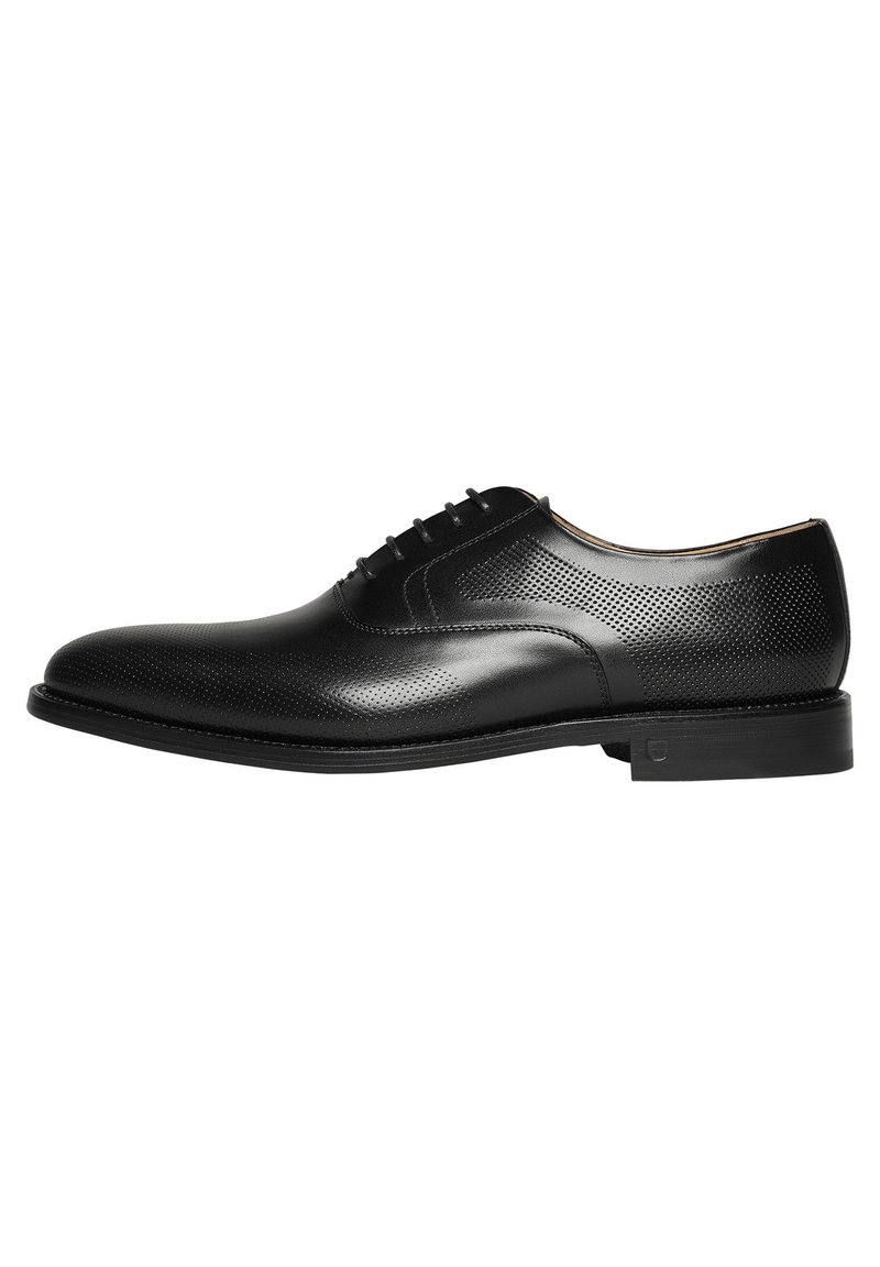 Schwarze Lederleder Schuhe mit perforiertem Design, abgerundeter Zehenform, Schnürverschluss und einer flachen Gummisohle, mit subtilen tonalen Akzenten.