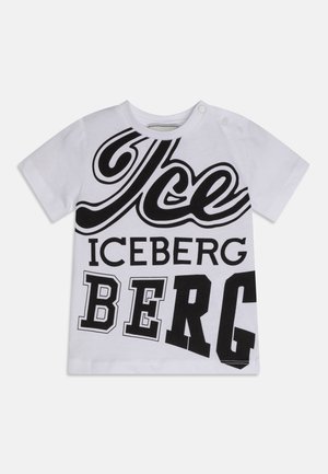 Hvid bomulds-T-shirt med fed sort tekst i forskellige skrifttyper: "Is," "ISBJERG" og "BJERG." Kortærmet med trykknapper på den ene skulder.