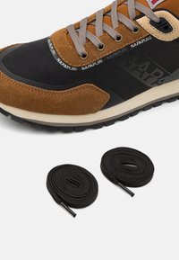 Sneaker marrone e nera realizzata con materiali in suede e tessuto, dotata di lacci grigi, suola nera e logo del marchio di lato. Include due lacci neri.