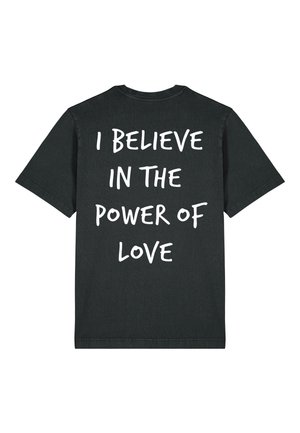Schwarzes T-Shirt mit kurzenärmeln und weißem Text auf der Rückseite mit dem Schriftzug „"I BELIEVE IN THE POWER OF LOVE"“ in handgeschriebener Schriftart.