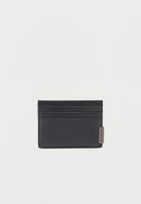 Portafoglio in pelle nera con più scomparti per carte e una piccola etichetta metallica etichettata "Tommy Hilfiger" nell'angolo in basso a destra.