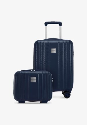 Maleta rígida texturizada azul marino con asa retráctil y ruedas giratorias, acompañada de una maleta de mano más pequeña a juego.