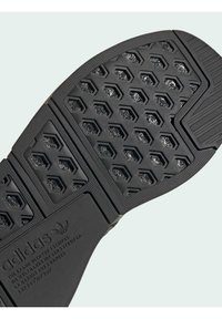 Sort Adidas skosål med hexagonale mønstre og struktureret greb, der har Adidas-logoet og brandtekst nær hælen.