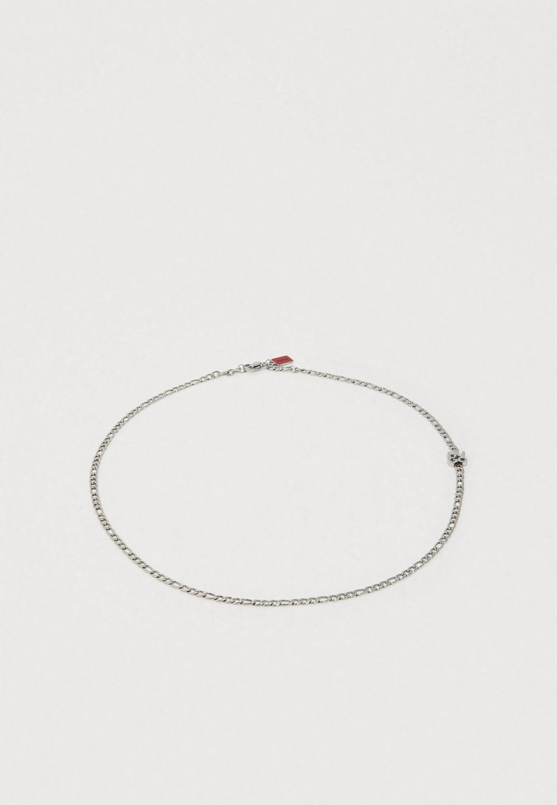 Ασημένιο κολιέ με αλυσίδα από μέταλλο με κομψό σχέδιο. Διαθέτει μικρούς κρίκους, κούμπωμα με κλειδαριά αστακού και κόκκινη λεπτομέρεια. Ομαλή υφή, μινιμαλιστική εμφάνιση.