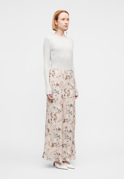 Μακρύ φλοράλ φόρεμα με εφαρμοστή γκρι κορυφή και ρέον, μοτίβο φούστα. Απαλό ύφασμα, παστέλ χρώματα και διακριτικά λουλουδάτα σχέδια.