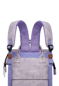 Mochila púrpura con correas acolchadas, que presenta una superficie texturizada, herrajes ajustables y acentos en contraste en marrón y azul marino.