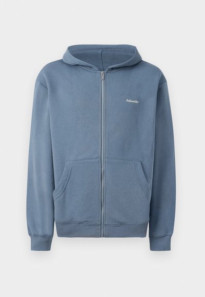 Felpa blu con zip realizzata in tessuto morbido, dotata di zip frontale, due tasche e polsini a coste. Piccolo logo sul petto.