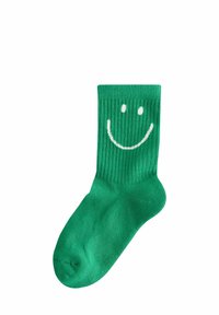 Grüne Baumwollsocke mit geripptem Muster, die in der Nähe des Oberteils ein weißes Smiley-Gesichtdesign aufweist. Standard Crew-Länge.