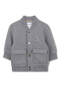 Szara kurtka dla malucha z zatrzaskami, dwoma przednimi kieszeniami z klapkami, prążkowanym kołnierzem i mankietami oraz wypukłym logo "B" na klatce piersiowej.