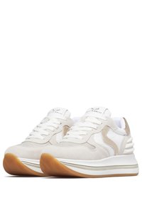 Zapatillas de deporte color beige claro con una combinación de materiales de ante y malla. Presenta cordones blancos, una puntera perforada y una suela de goma color caramelo. Acentos plateados.