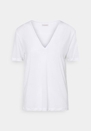 Biały damski T-shirt z krótkim rękawem i dekoltem w serek o luźnym kroju, przedstawiony na jednolitym jasnym tle.