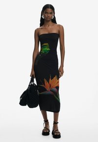 Black strapless dress featuring vibrant tropical bird and flower prints. Material is fitted, with a smooth texture and mid-calf length.