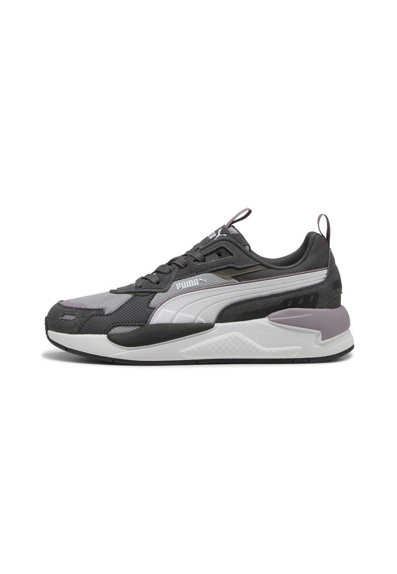 Scarpa sportiva con una parte superiore in tessuto grigio, accenti bianchi e suola nera texturizzata. Presenta un tallone imbottito e un dettaglio del logo in evidenza.