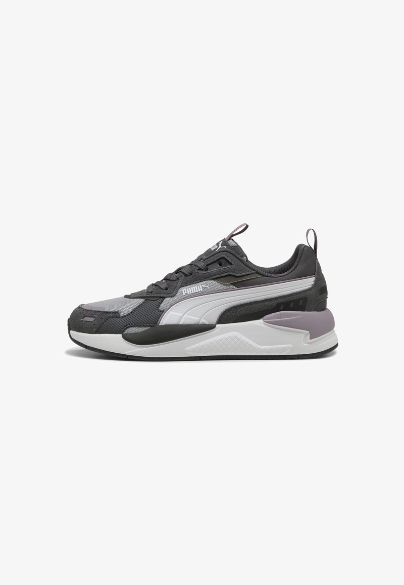 Scarpa sportiva con una parte superiore in tessuto grigio, accenti bianchi e suola nera texturizzata. Presenta un tallone imbottito e un dettaglio del logo in evidenza.