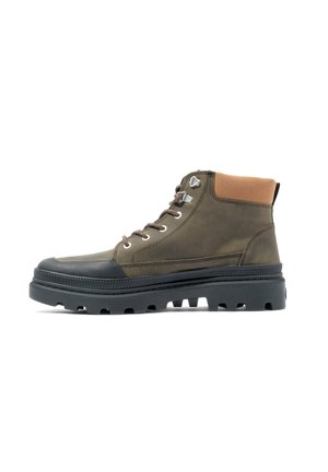 Bottines vert olive avec un col en cuir suédé marron, un capuchon en caoutchouc, des œillets métalliques et une semelle extérieure noire robuste avec de profondes crampons.