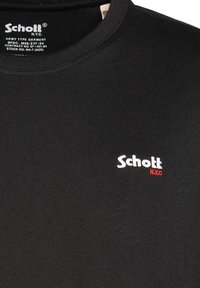 T-shirt in cotone nero con scollatura a girocollo, texture liscia e logo "Schott" ricamato in bianco con dettagli rossi.
