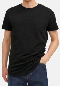 T-shirt nera a girocollo realizzata in cotone, con maniche corte e una vestibilità comoda. Il tessuto appare liscio e con una leggera elasticità.
