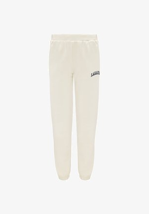 Krémové tepláky vyrobené z mäkkej tkaniny, s elastickým pásom a manžetami, s námorníckym modrým logom na ľavom stehne.