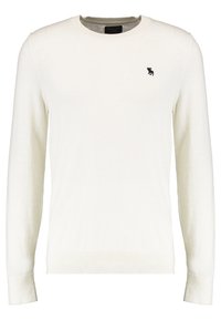 Suéter blanco de punto con mangas largas, cuello redondo y puños acanalados. Presenta un pequeño logo oscuro en el pecho. Textura suave y ajuste clásico.