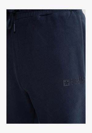 Tumesinised dressipüksid, millel on elastne vöökoht, pael ja "BIG STAR" logo ülemisel reiel.